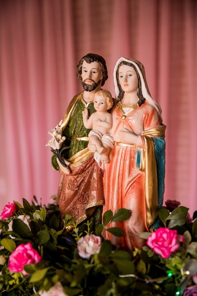 红色和绿色花卉织物上的圣母玛利亚雕像